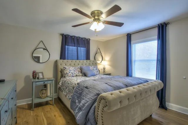 a bedroom with a large bed and two windows