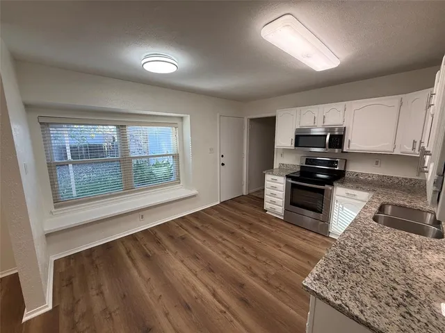 a kitchen with stainless steel appliances granite countertop a stove a sink and a microwave