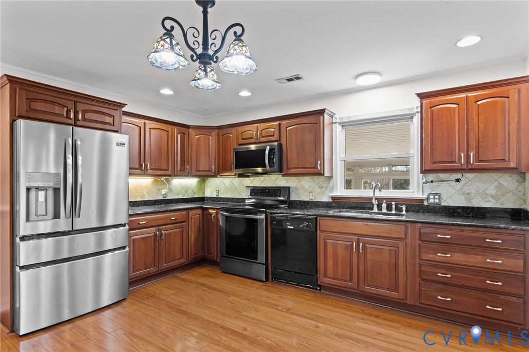 5359 Qualla Road Chesterfield, VA 23832 - Photo 14 of 49 a kitchen with stainless steel appliances granite countertop a refrigerator a stove top oven a sink and dishwasher with wooden floor