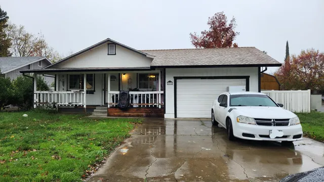 a front view of a house with a garden and trees