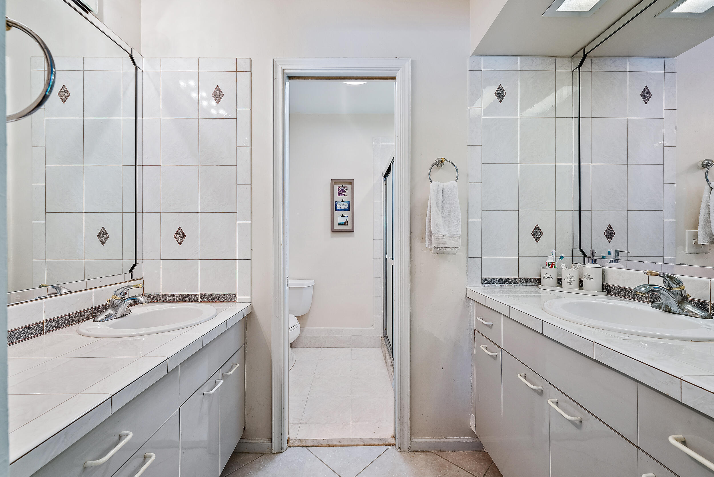 83 Fairview West Tequesta, FL 33469 - Photo 16 of 32 a bathroom with a sink double vanity and a mirror