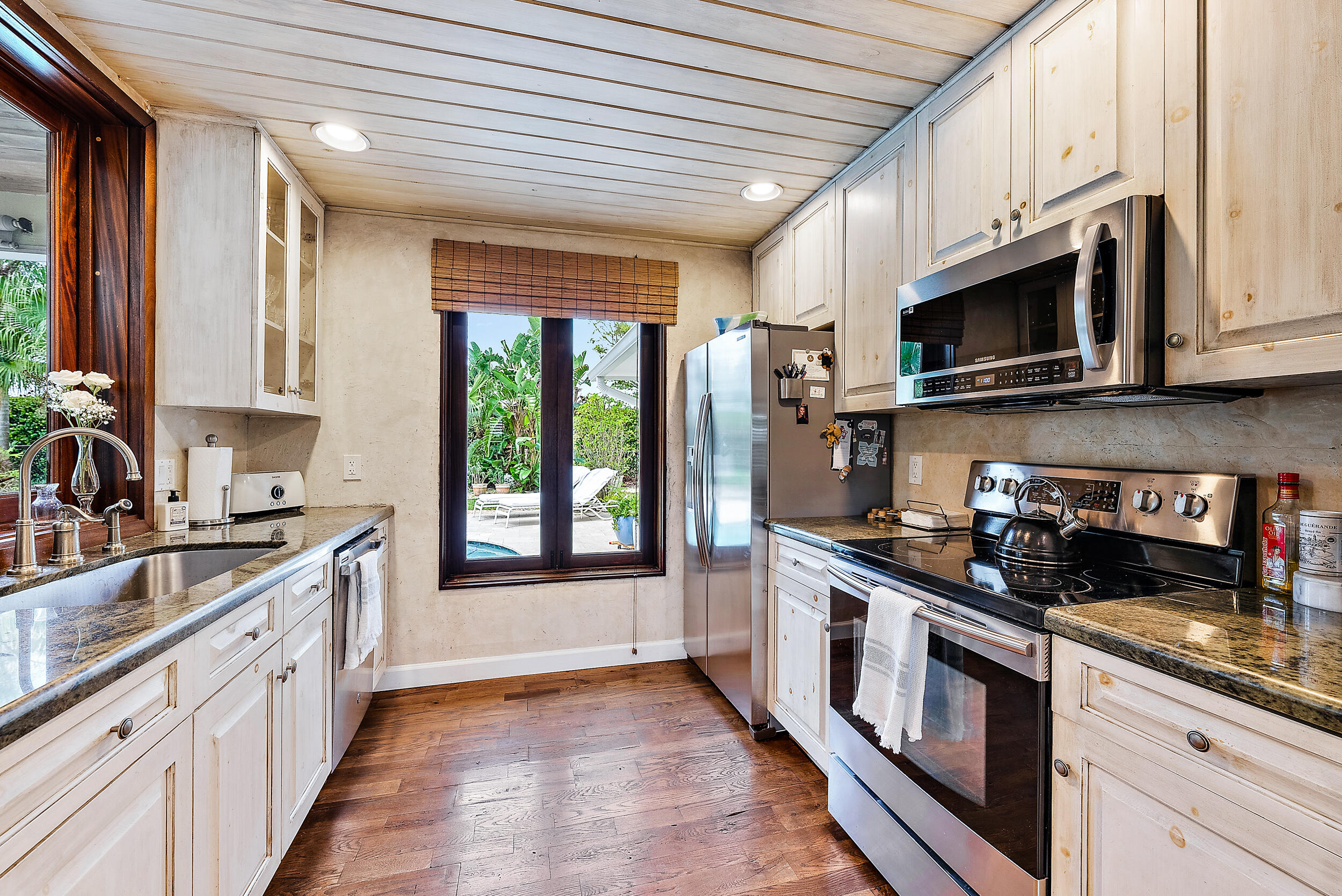 83 Fairview West Tequesta, FL 33469 - Photo 9 of 32 a kitchen with stainless steel appliances granite countertop a stove a sink and a microwave