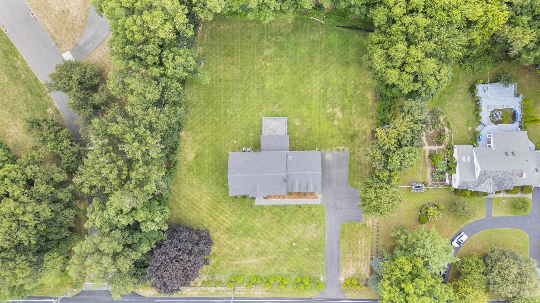 an aerial view of a house with a yard basket ball court and outdoor seating
