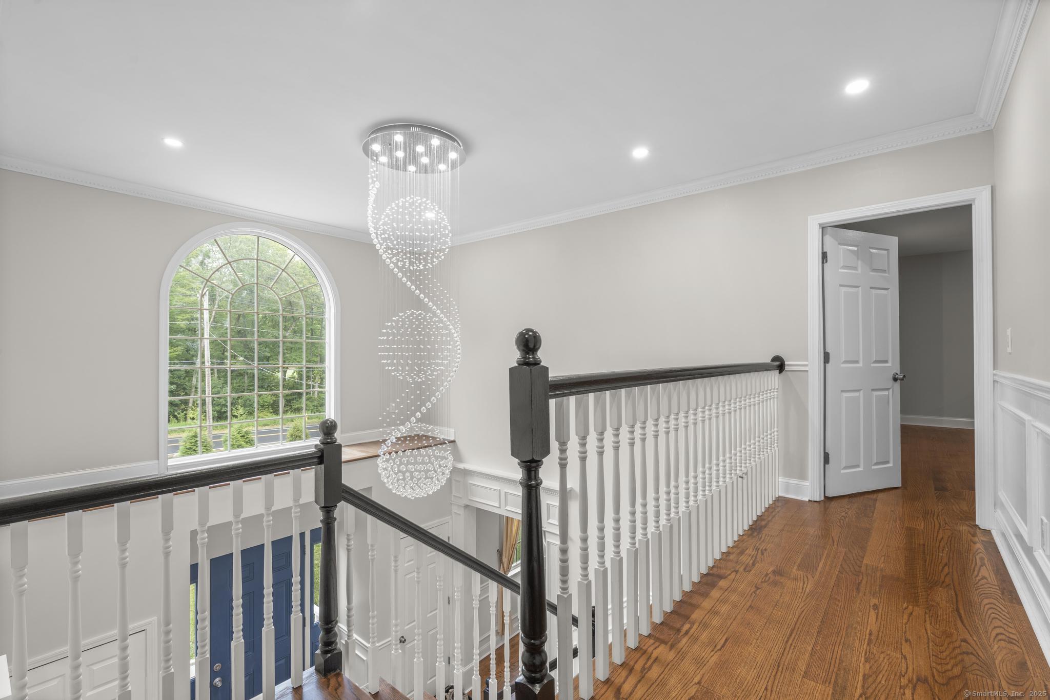 424 Racebrook Road Orange, CT 06477 - Photo 13 of 36 a view of a hallway with wooden floor and stairs
