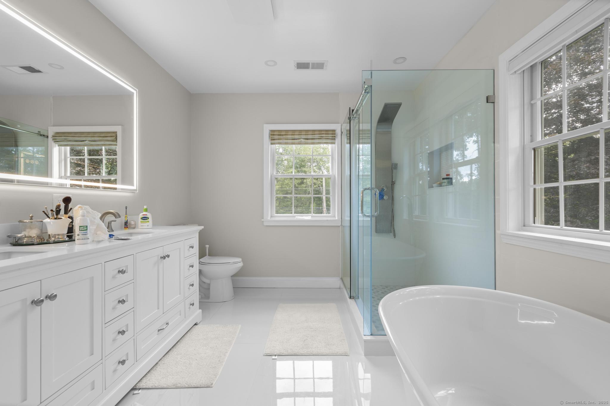 424 Racebrook Road Orange, CT 06477 - Photo 16 of 36 a spacious bathroom with double vanity sink a mirror a window and a shower