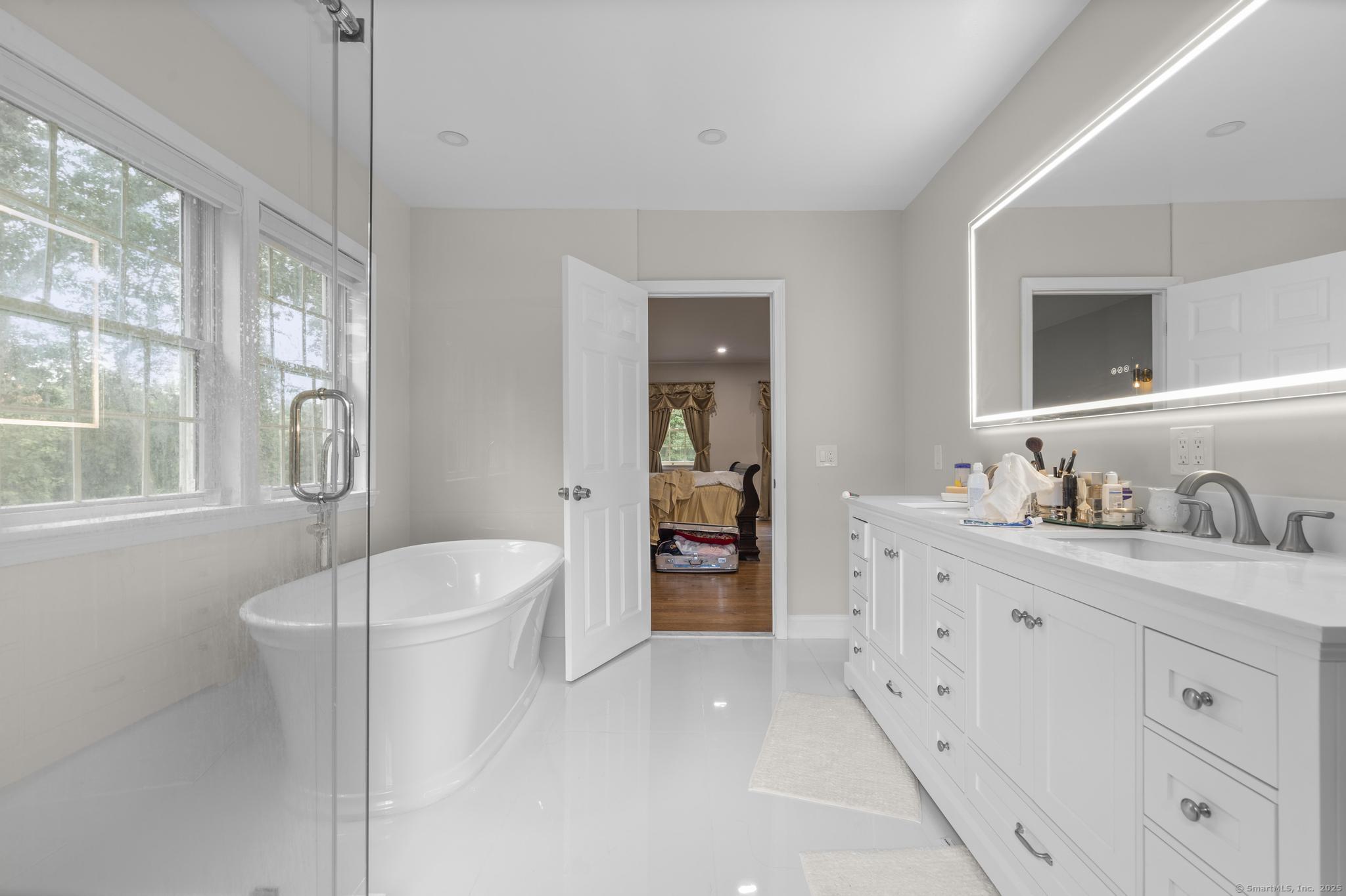 424 Racebrook Road Orange, CT 06477 - Photo 17 of 36 a spacious bathroom with a double vanity sink a mirror and a bathtub