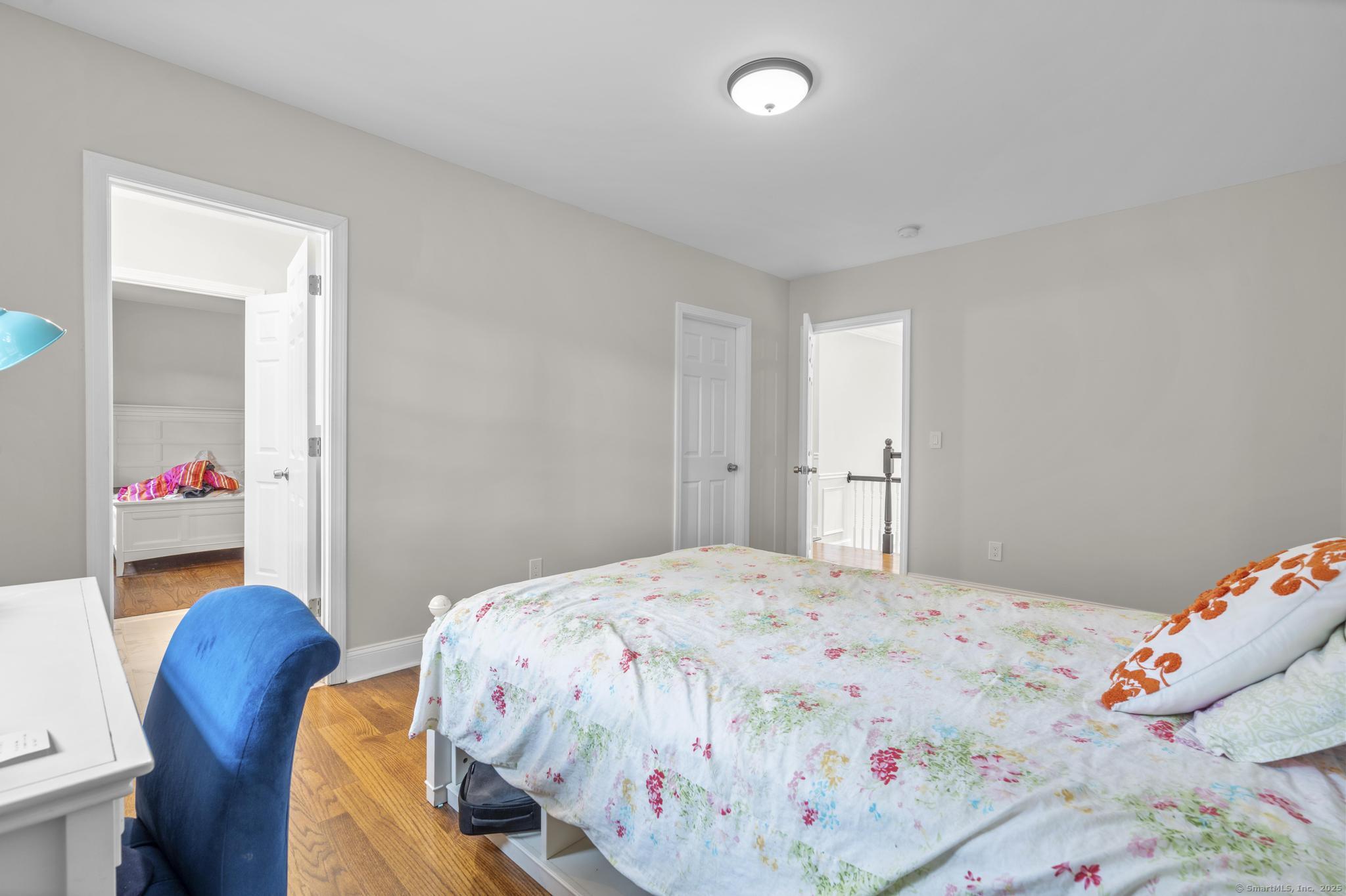 424 Racebrook Road Orange, CT 06477 - Photo 23 of 36 a bedroom with a bed and a chandelier