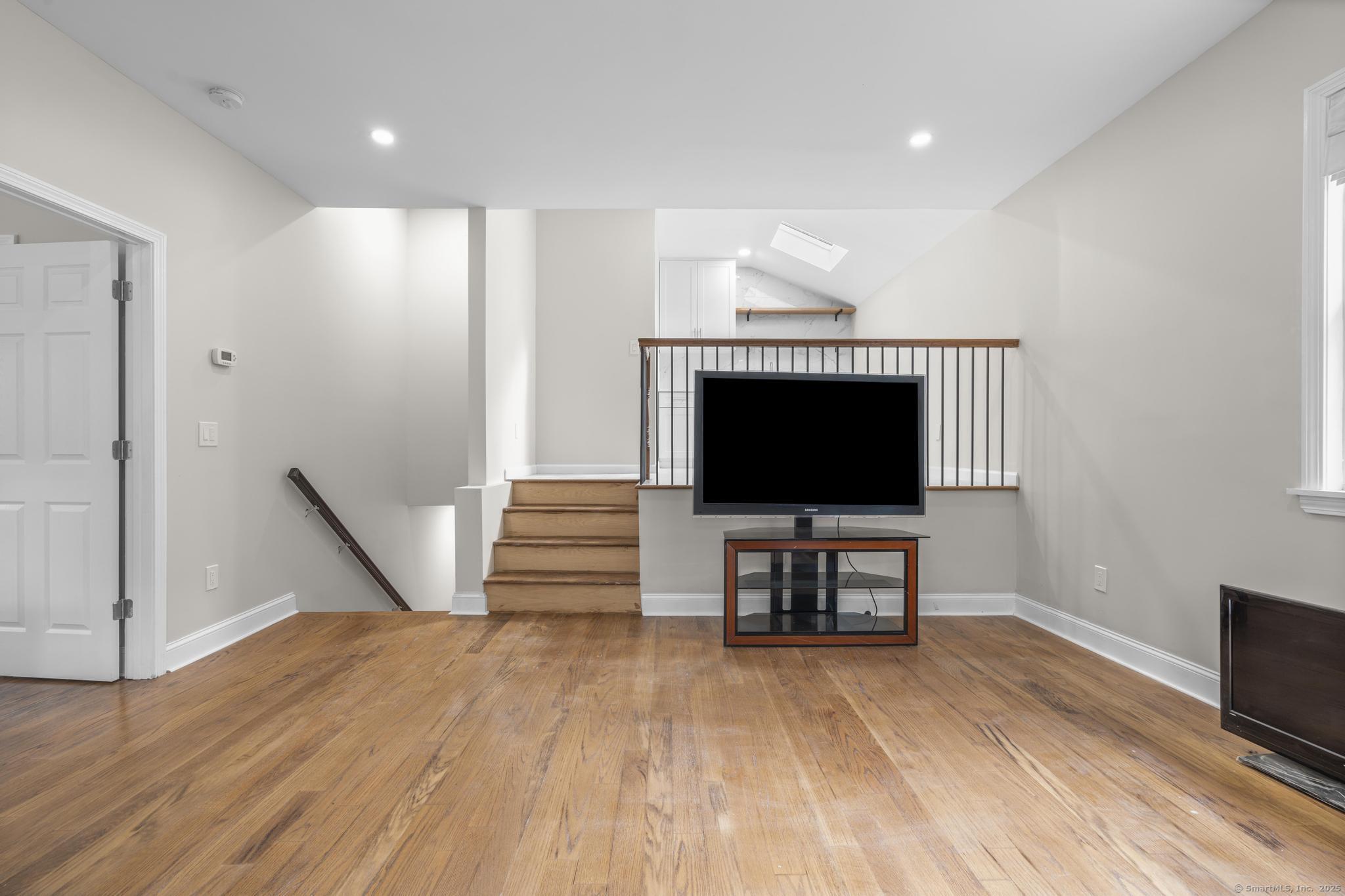 424 Racebrook Road Orange, CT 06477 - Photo 24 of 36 a view of a livingroom with wooden floor and a flat screen tv