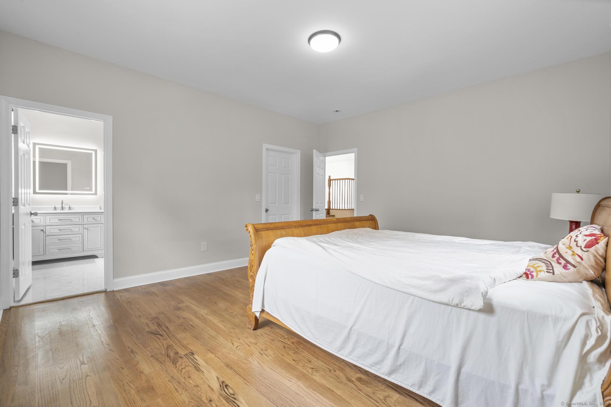 424 Racebrook Road Orange, CT 06477 - Photo 27 of 36 a bedroom with a bed and a wooden floor