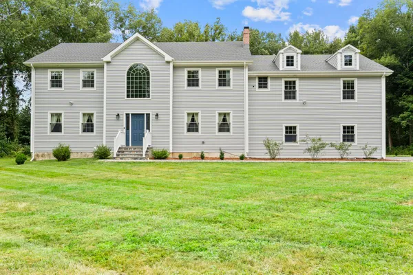 a front view of house with yard and green space