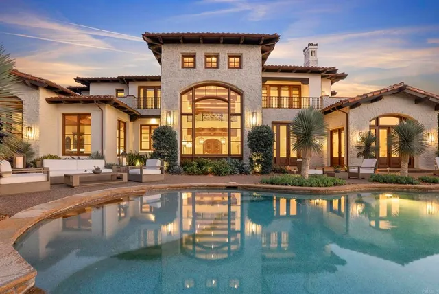 a front view of a house with swimming pool and small yard