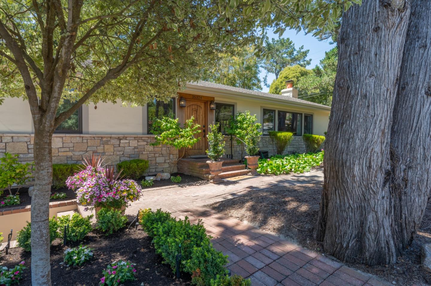 25324 Hatton Road Carmel, CA 93923 - Photo 17 of 19 a front view of a house with a yard and potted plants