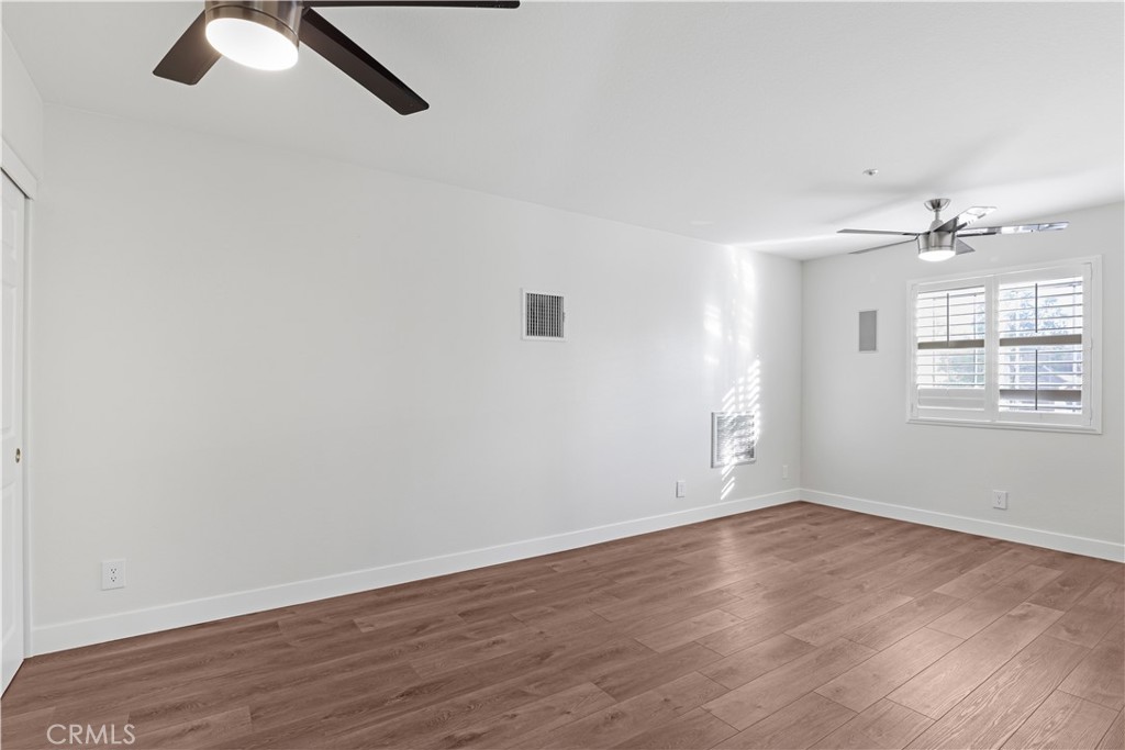 19 Garrison Loop Ladera Ranch, CA 92694 - Photo 17 of 21 an empty room with wooden floor fan and windows