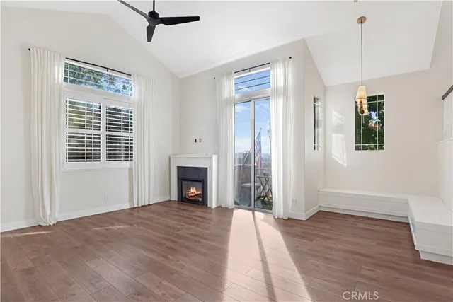 a view of empty room with wooden floor and fireplace