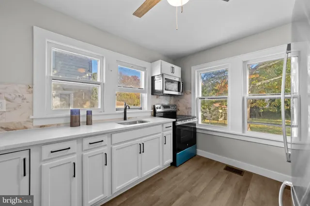 a kitchen with white cabinets and stainless steel appliances
