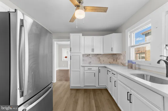 a kitchen with granite countertop white cabinets and stainless steel appliances