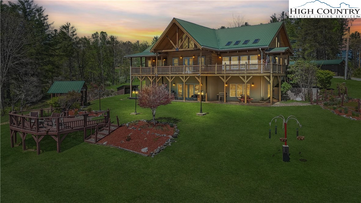 a view of a big house with a big yard and large trees