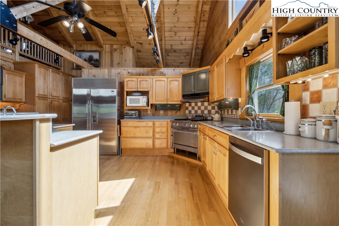 101 Double Branch Road Grassy Creek, NC 28631 - Photo 13 of 50 a kitchen with stainless steel appliances granite countertop a sink a stove and a wooden cabinets