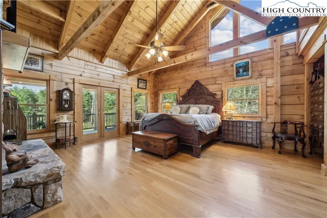 a spacious bedroom with a bed and wooden floor