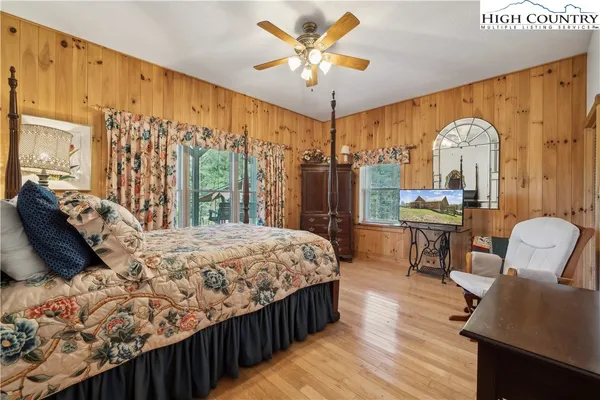a bedroom with a bed window and a flat tv screen