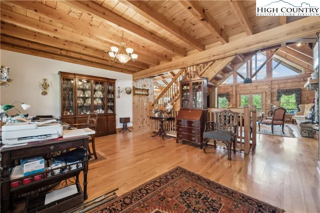 a dining room with lots of wooden furniture and a chandelier