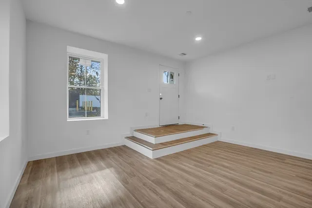 a view of room with window and wooden floor