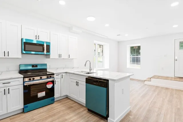 a kitchen with a sink stove top oven and cabinets