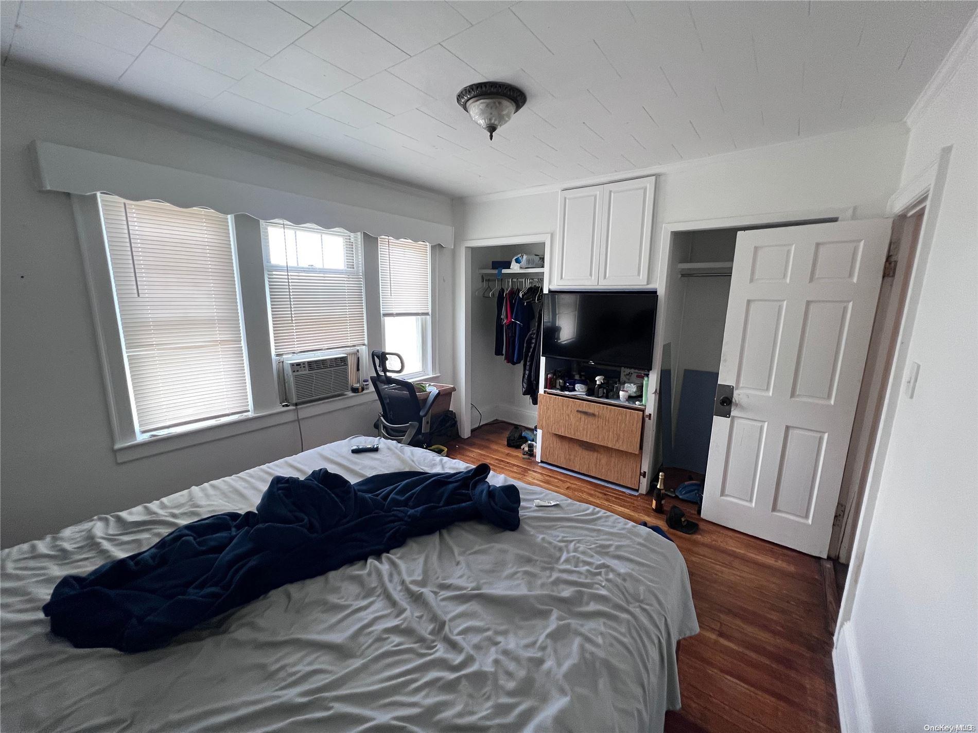 91-18 87th Street Queens, NY 11421 - Photo 12 of 22 a bedroom with a bed and wooden floor