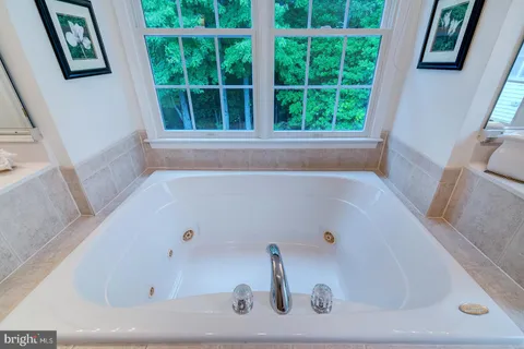 an aerial view of a house with outdoor space lake view and trees all around