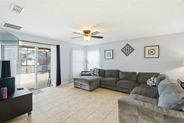a living room with furniture and a ceiling fan