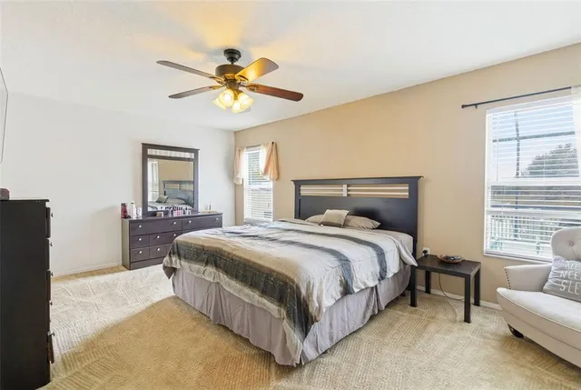 a spacious bathroom with a granite countertop sink a toilet a mirror and shower