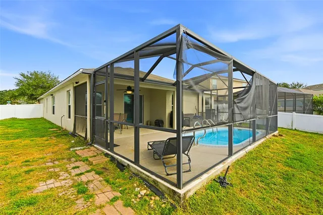 a view of a house with a backyard and a tree