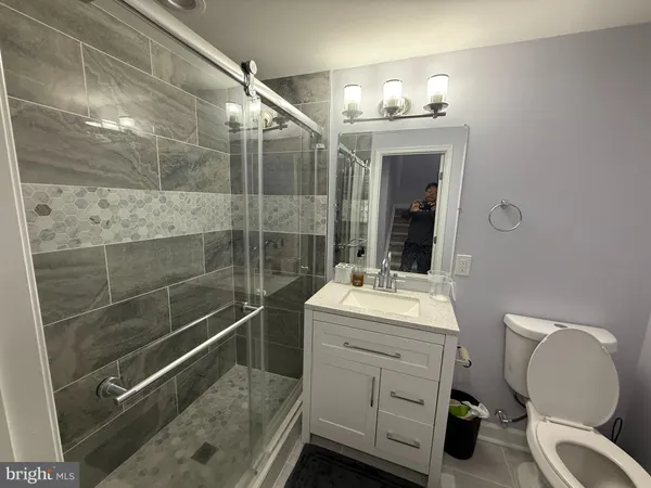 a bathroom with a sink mirror and a toilet