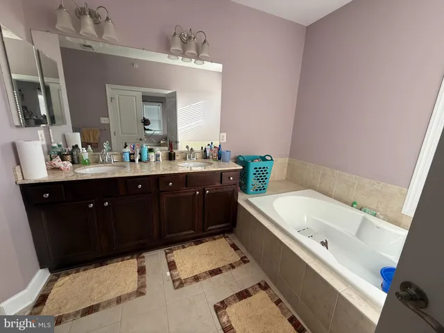 a bathroom with a tub sink and mirror