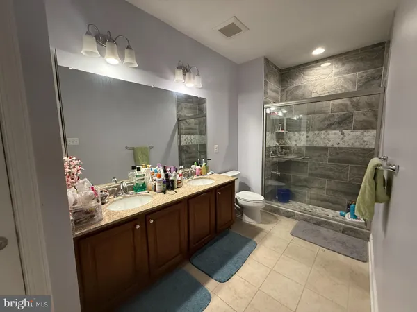 a bathroom with a double vanity sink mirror and shower