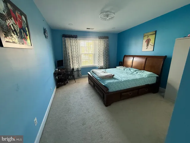 a bedroom with a bed and painting on the wall