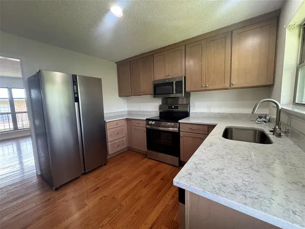 a kitchen with a sink a microwave a refrigerator and cabinets
