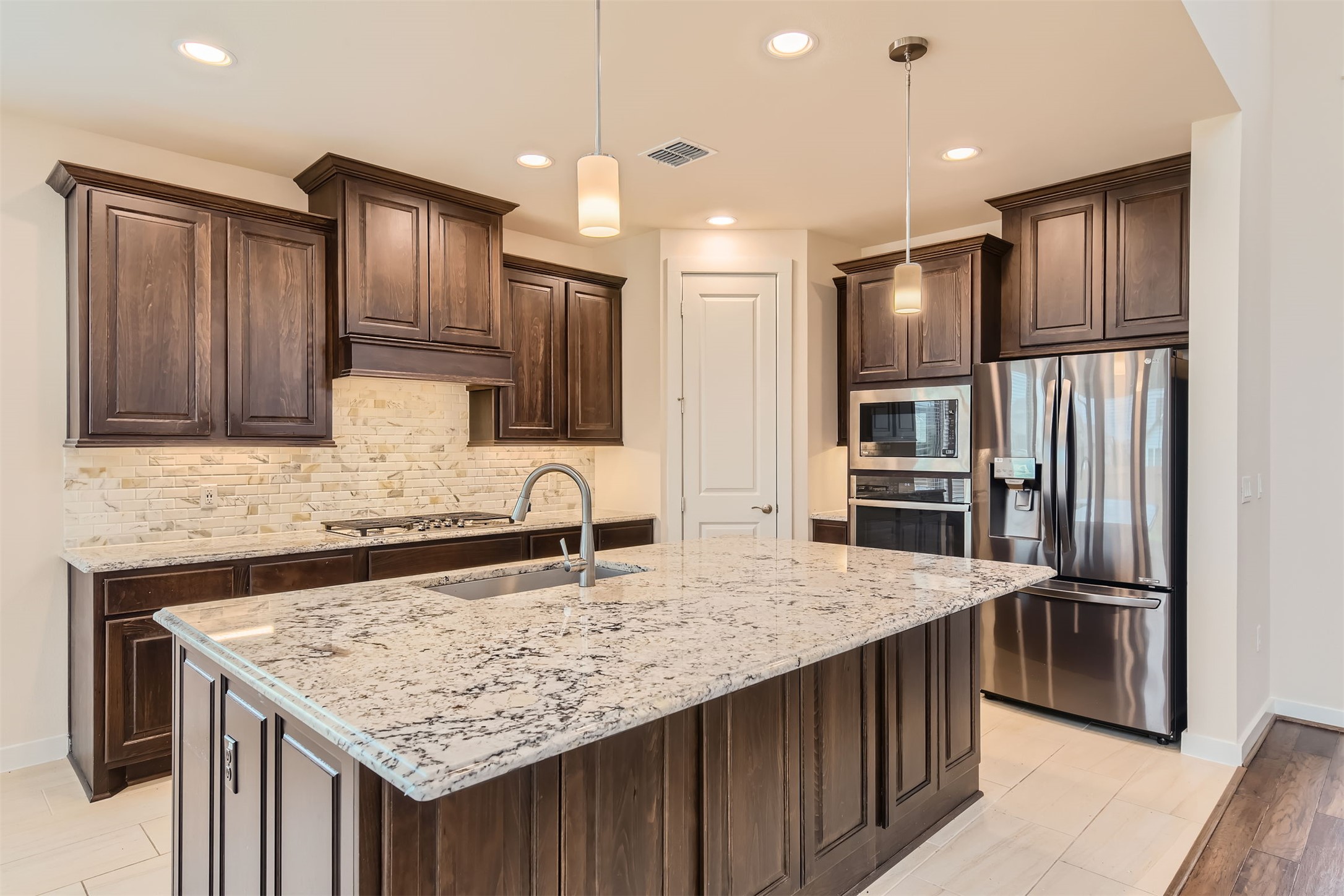 8313 Spire View Austin, TX 78744 - Photo 10 of 33 A gourmet kitchen offers rich cabinetry, granite countertops, and modern stainless steel appliances.