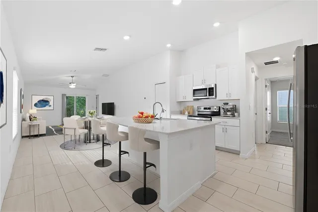 a kitchen with stainless steel appliances kitchen island granite countertop a refrigerator and cabinets