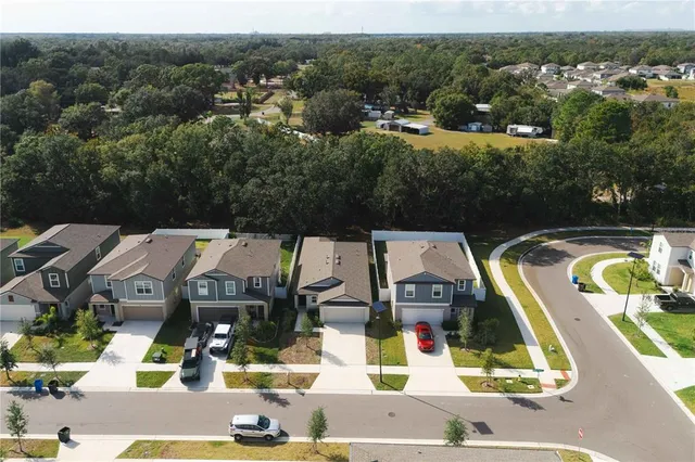 an aerial view of residential houses with outdoor space and swimming pool