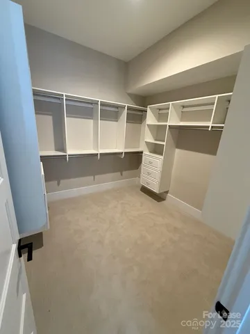 a view of walk in closet with clothes and shoes