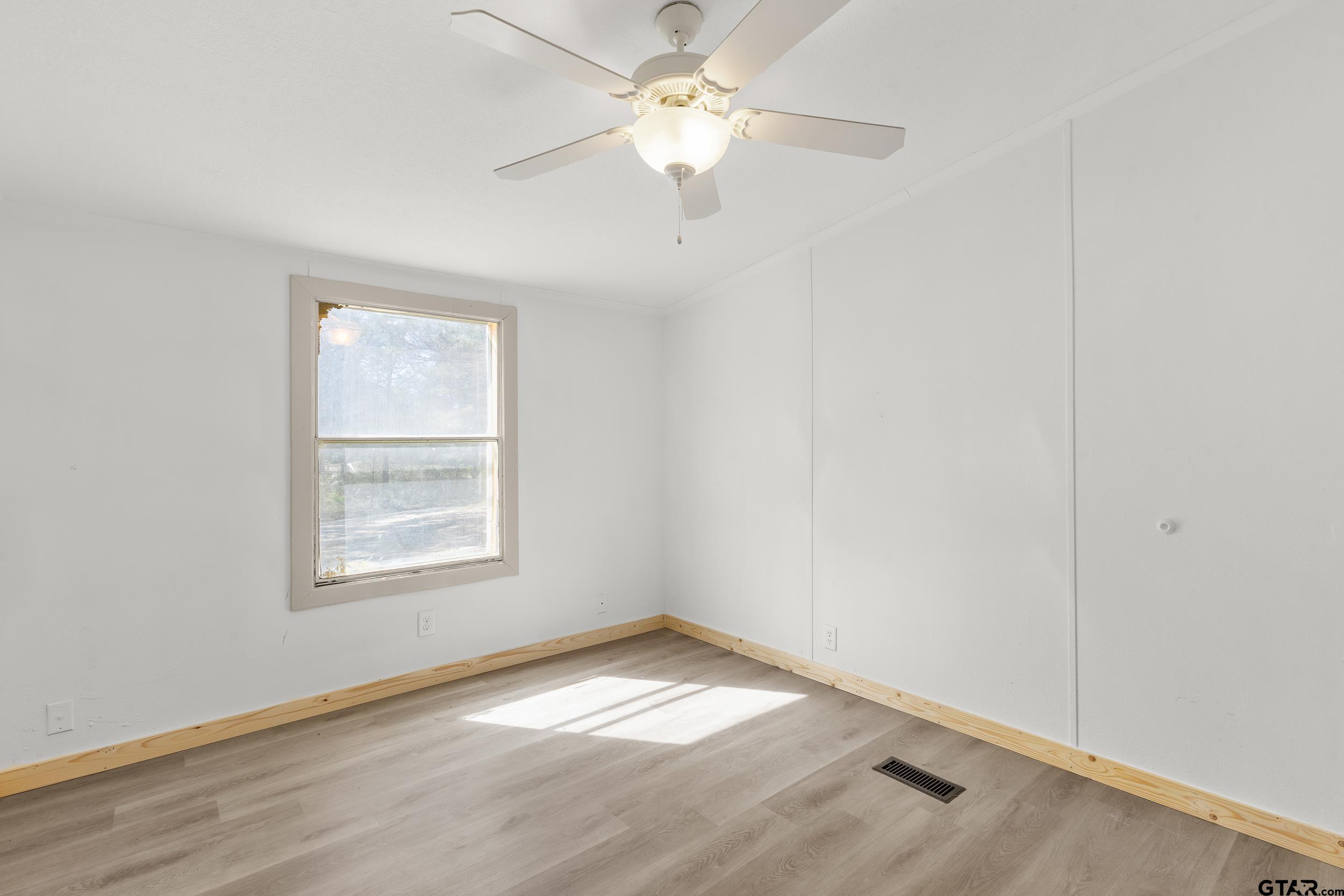 180 Southeast County Road Southeast Mount Vernon, TX 75457 - Photo 16 of 32 an empty room with a window and a fan