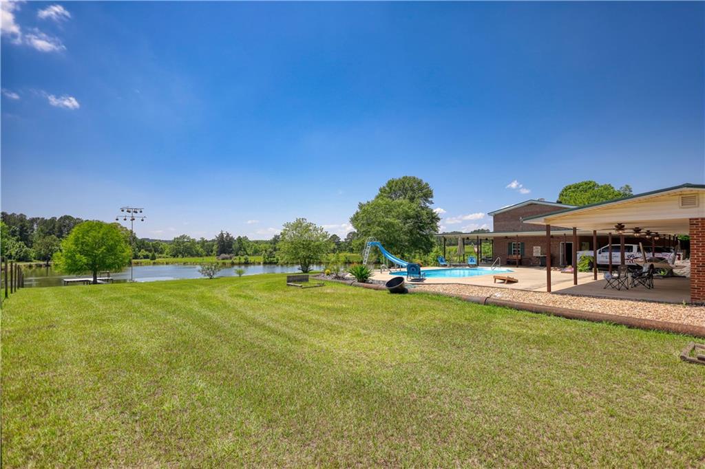 947 Bellhouse Road Macon, GA 31217 - Photo 61 of 132 a view of a swimming pool with lawn chairs and a big yard