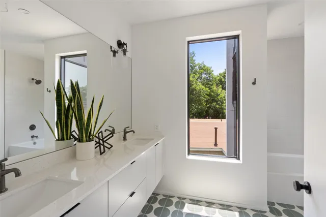 a bathroom with a bathtub a sink and a window