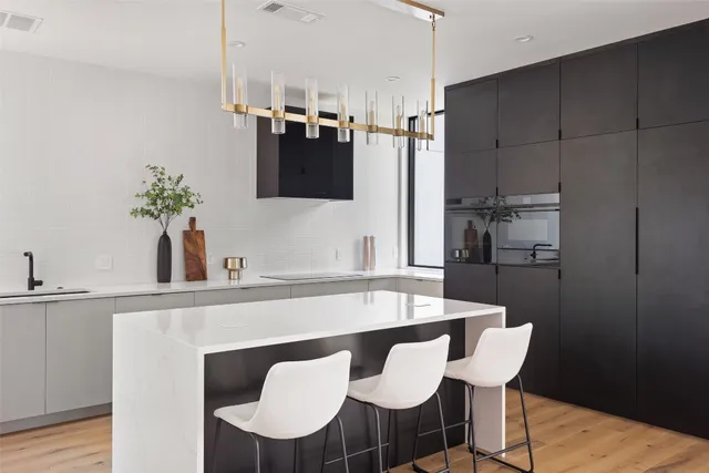 a kitchen with a dining table chairs and white cabinets