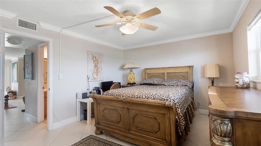 1169 Hillsboro Mile, Unit 717 Hillsboro Beach, FL 33062 - Photo 12 of 37 a bedroom with a bed and a chandelier