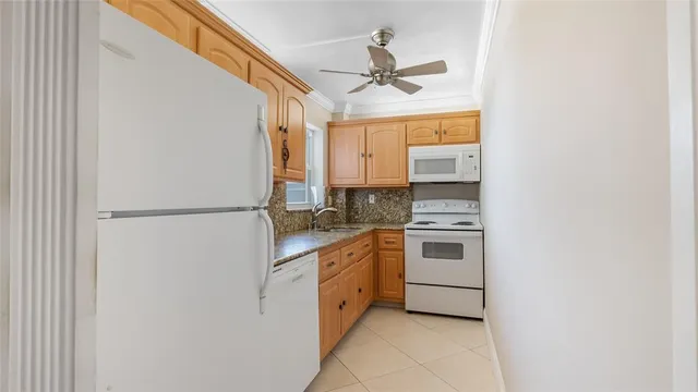 a kitchen with granite countertop a refrigerator and a stove top oven