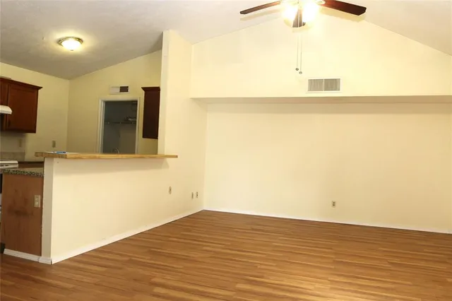 a view of empty room with wooden floor