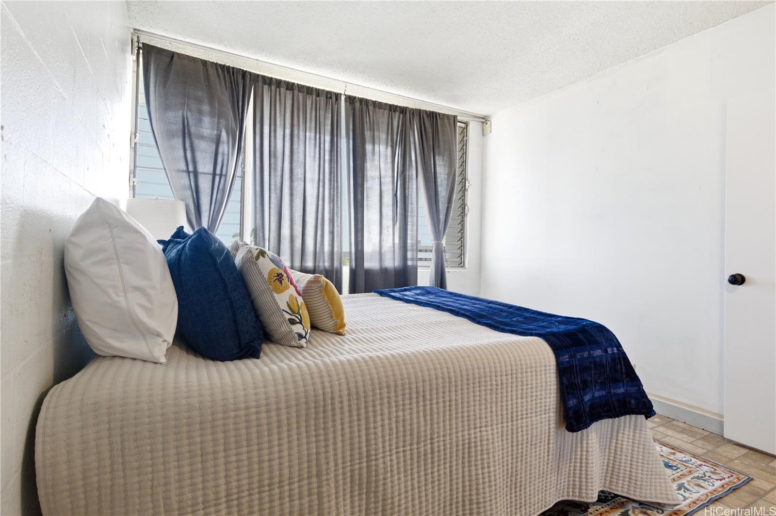 94-249 Waikele Road, Unit B313 Waipahu, HI 96797 - Photo 13 of 13 a bedroom with a bed and a window