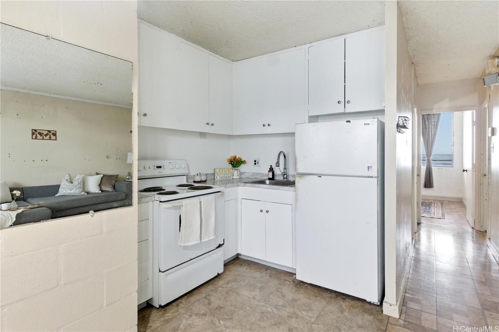 94-249 Waikele Road, Unit B313 Waipahu, HI 96797 - Photo 2 of 13 a kitchen with a refrigerator stove and white cabinets